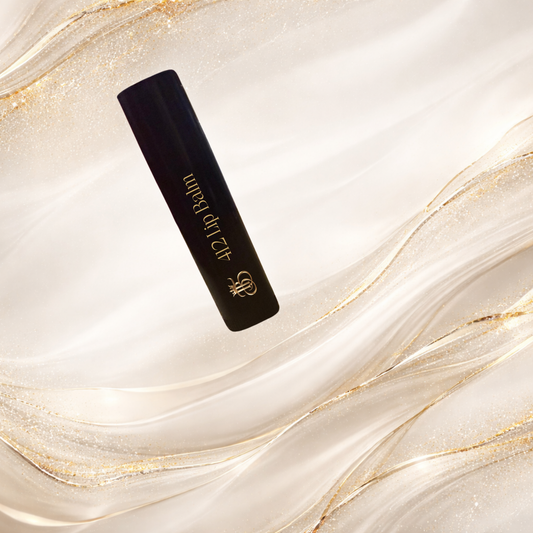 Sleek 412™ Tremilo Lip Balm tube on a soft, neutral marble background, showcasing black tube with gold logo and label.