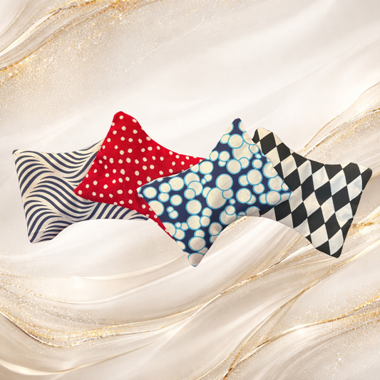 Collection of small Palm & Pulse™ Comfort Compresses in various patterns including chevron, plaid, bubbles, stars, and anchors, filled with natural buckwheat hulls for hot or cold therapy.