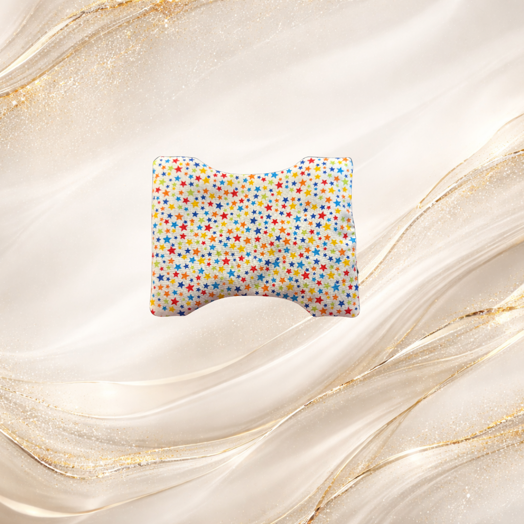 Small Palm & Pulse™ Comfort Compress featuring a multicolored star pattern on white fabric, filled with breathable buckwheat hulls for stress relief and tension support.