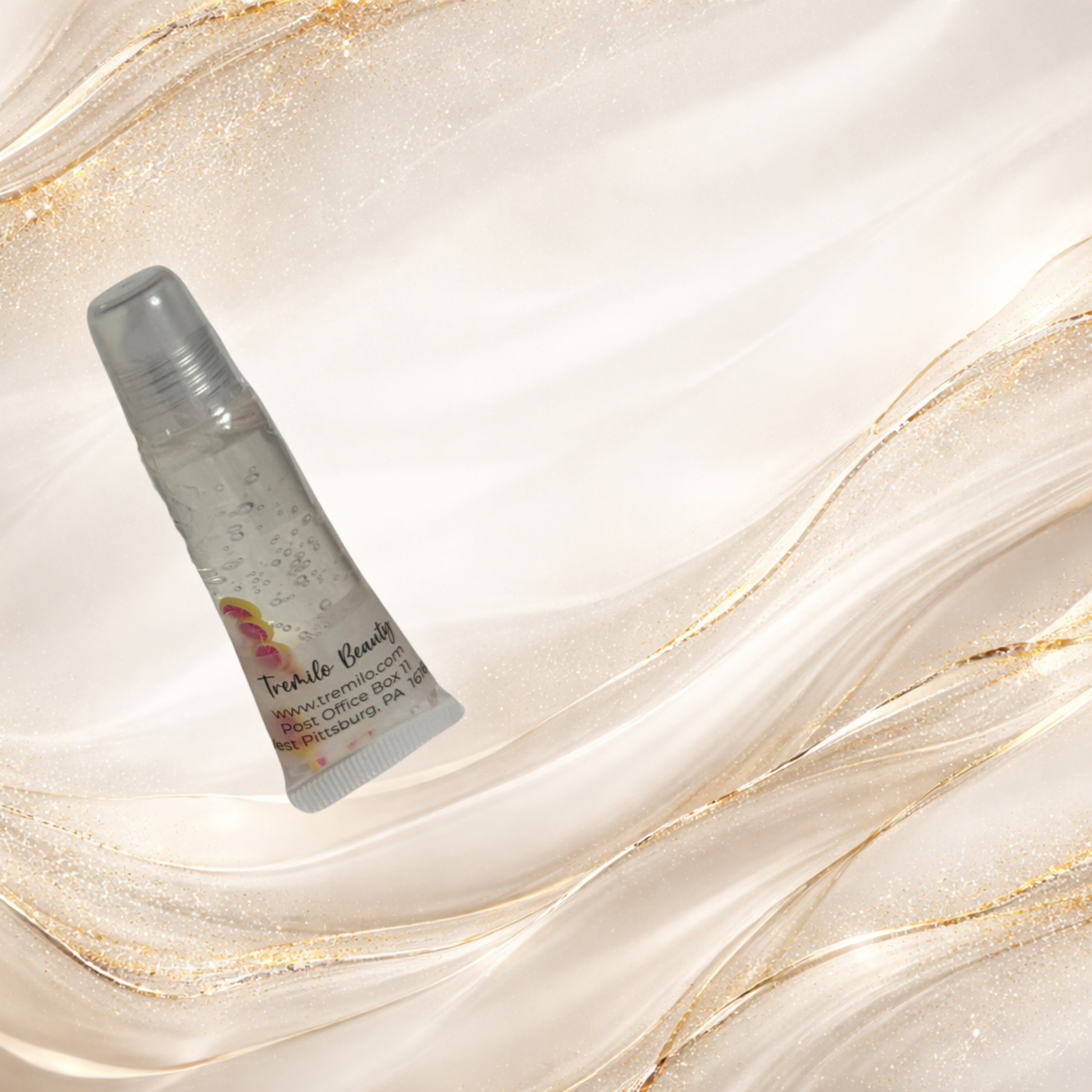 Pink Lemonade Kiss™ lip gloss standing on light marble-gold background, showing floating pink lemon slice charms inside