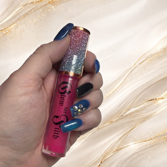 Candikill Astral Tease pink lip gloss by Tremilo Beauty held in hand featuring vibrant hot pink shimmer gloss with glitter cap.