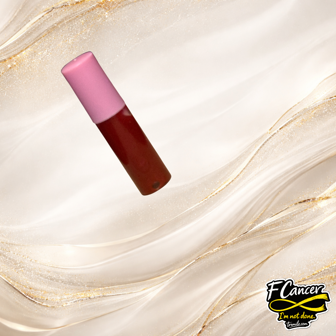 Close-up of F Cancer lip gloss tube by Tremilo Beauty showing red gloss inside decorative container