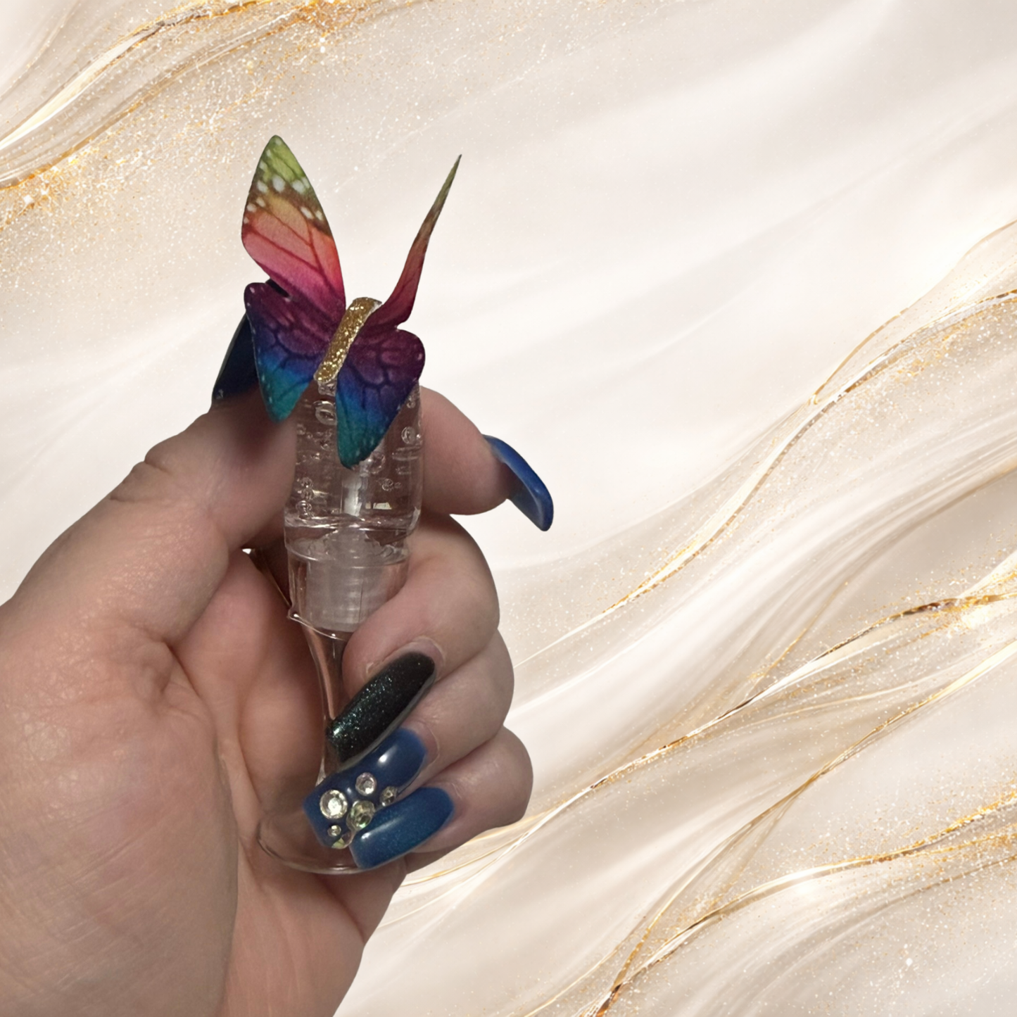 Flutterlight clear lip gloss displayed in a champagne glass with rainbow butterfly charm cap.