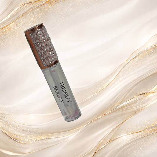 Flutterlight clear lip gloss tube with suspended star glitter and pearl embellished cap.