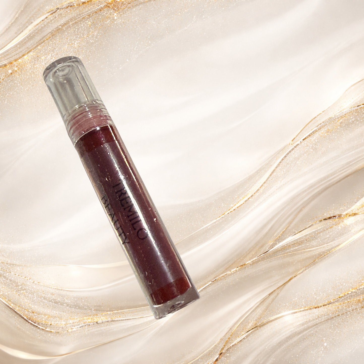 Mourningwould Tremilo lip gloss in clear tube displaying deep red glossy pigment