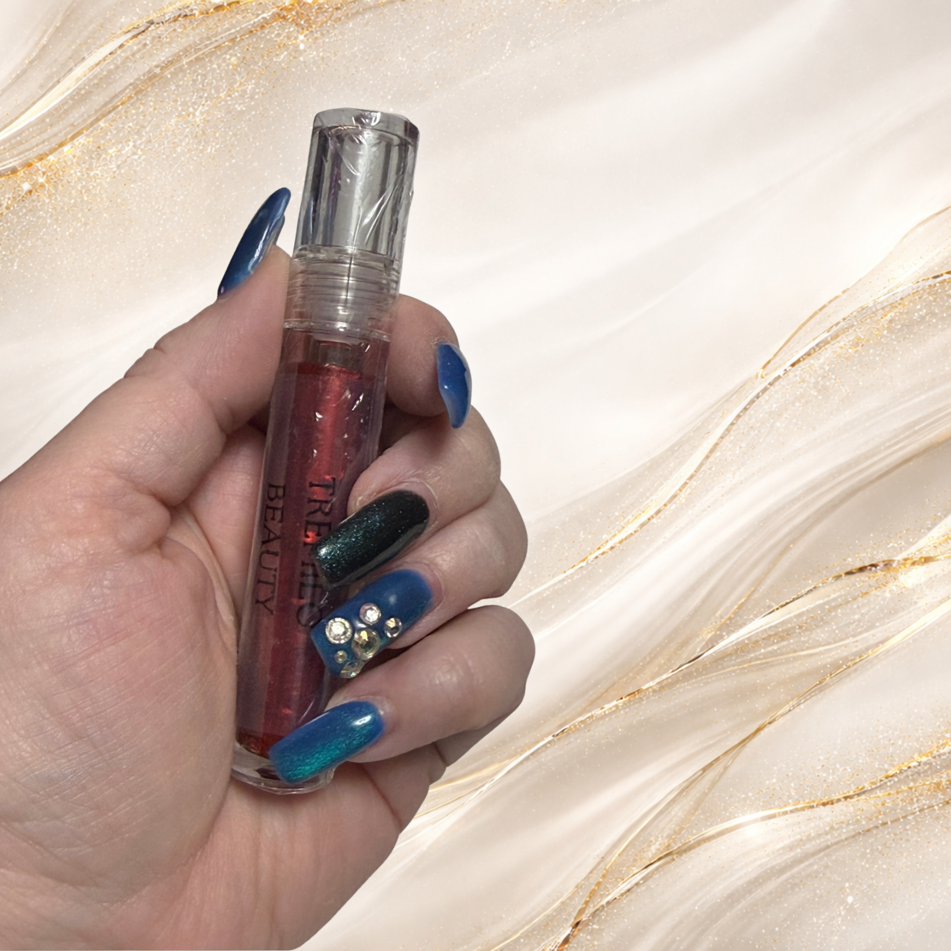 Steelheart red lip gloss in regular clear tube held in hand from the Tremilo Steel City Gloss Collection  