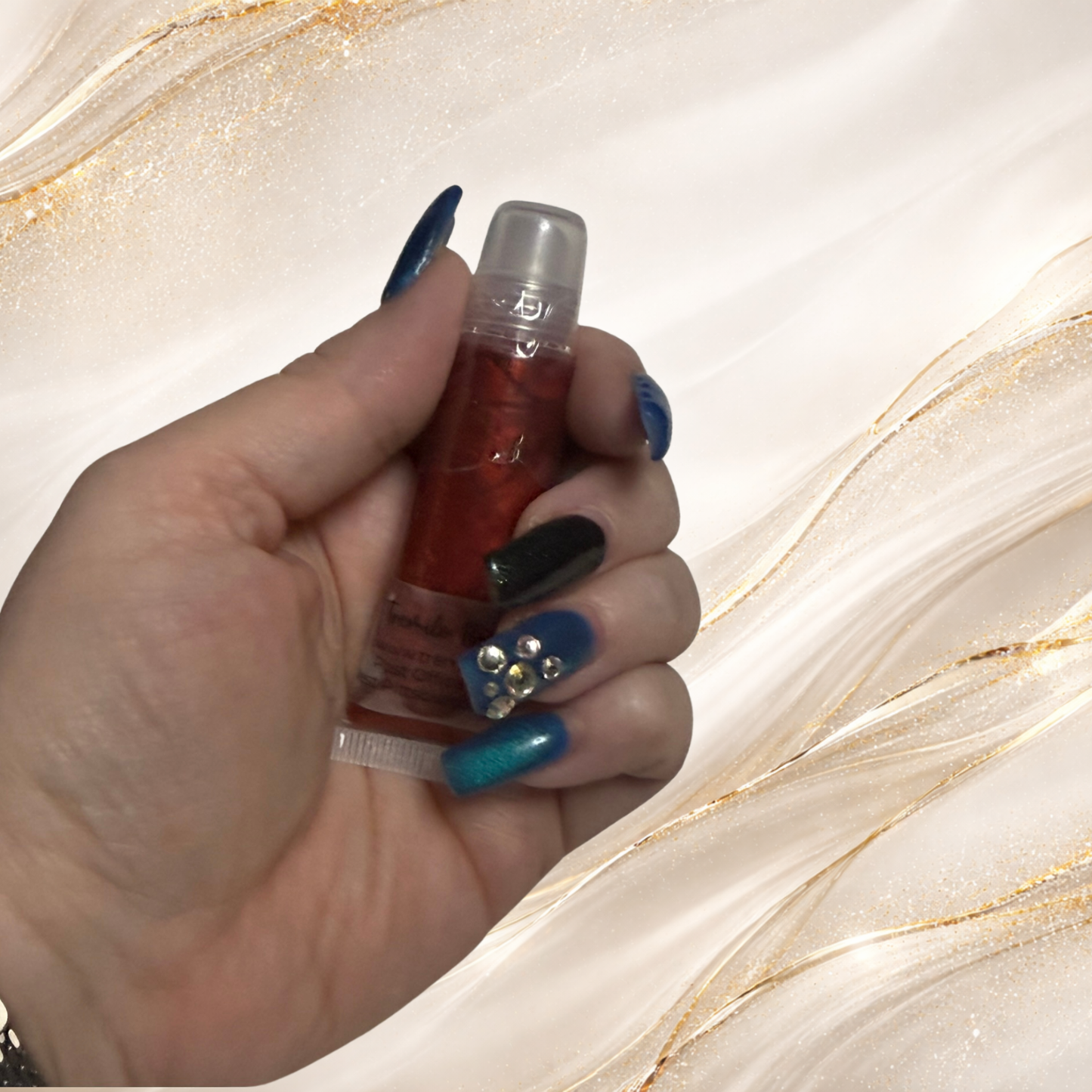 Steelheart red lip gloss squeeze tube held in hand showing high shine Steel City Gloss from Tremilo