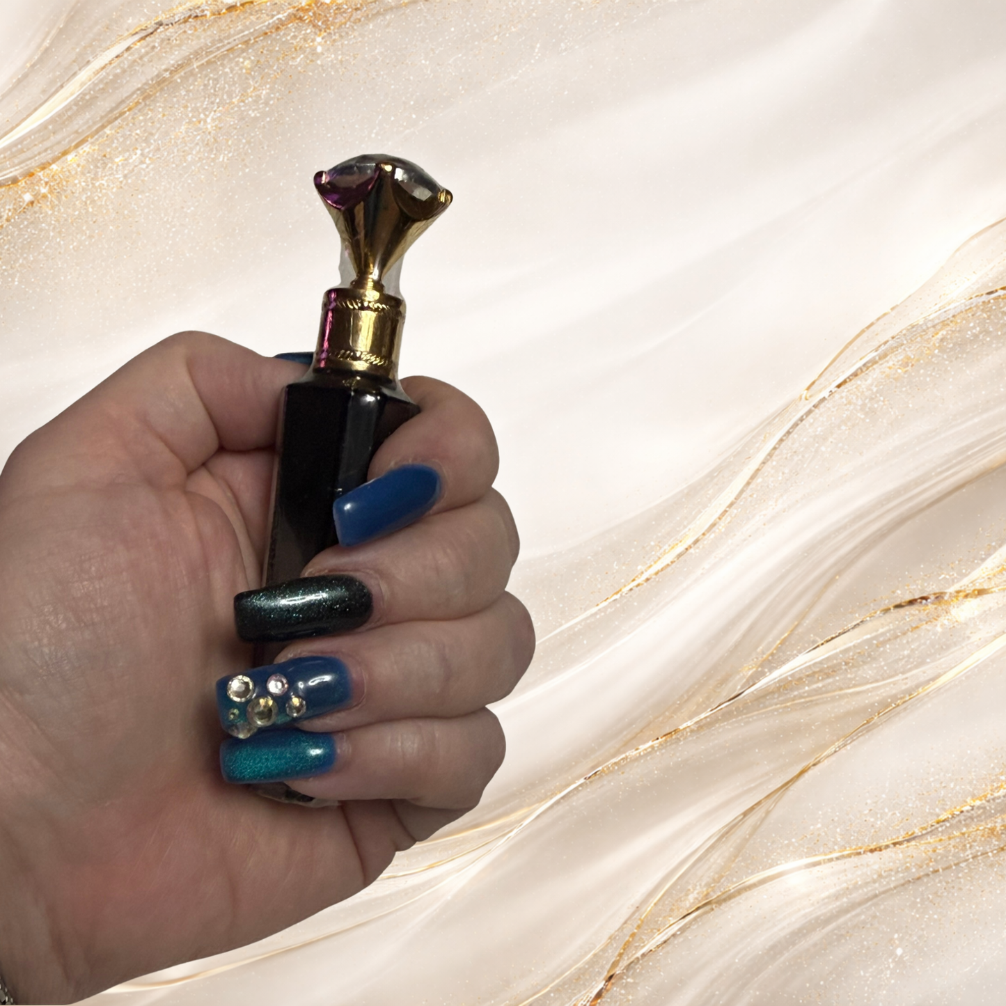 Black Gold Gloss lip gloss from Tremilo Beauty held in hand showing jewel topper and tube design