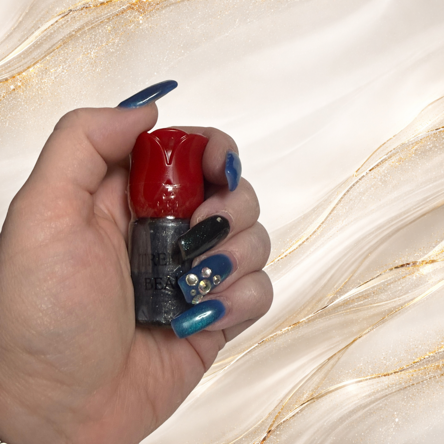 Black Gold Gloss in red rose tube from Tremilo Beauty held in hand showing gothic black shimmer gloss