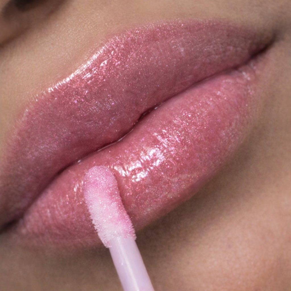 Three Rivers Rose lip gloss from Tremilo Beauty applied to lips with doe foot applicator showing rose pink shimmer gloss