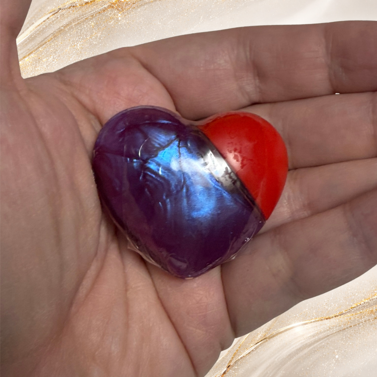 Violet Confluence purple lip gloss in heart shaped tube held in hand from the Tremilo Steel City Gloss Collection